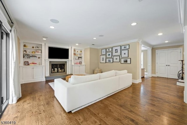 325 Hobar Ct, Franklin Lakes Boro, NJ 07417 - living room with crown molding, recessed lighting, a fireplace with raised hearth, wood finished floors, and built in shelves