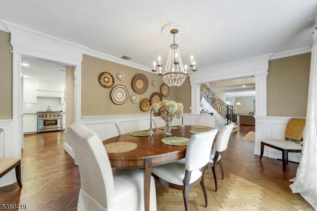 325 Hobar Ct, Franklin Lakes Boro, NJ 07417 - dining area with a decorative wall, a chandelier, ornamental molding, a wainscoted wall, and ornate columns