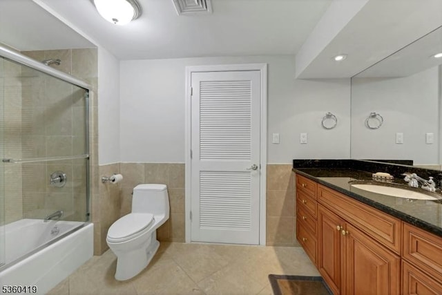 325 Hobar Ct, Franklin Lakes Boro, NJ 07417 - bathroom featuring tile walls, tile patterned floors, vanity, toilet, and combined bath / shower with glass door