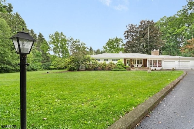 6 Evergreen Pl, Washington Twp, NJ 07840 - view of green lawn featuring an attached garage and asphalt driveway