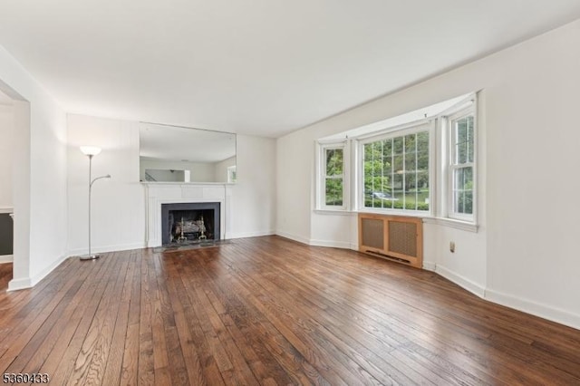 8 Pine Tree Ter, Madison Boro, NJ 07940 - unfurnished living room featuring radiator heating unit, hardwood / wood-style floors, a fireplace with flush hearth, and baseboards