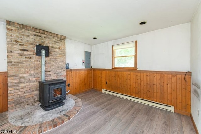 110 Shore Rd, Green Twp, NJ 07821 - unfurnished living room with baseboard heating, electric panel, wainscoting, wood finished floors, and wood walls