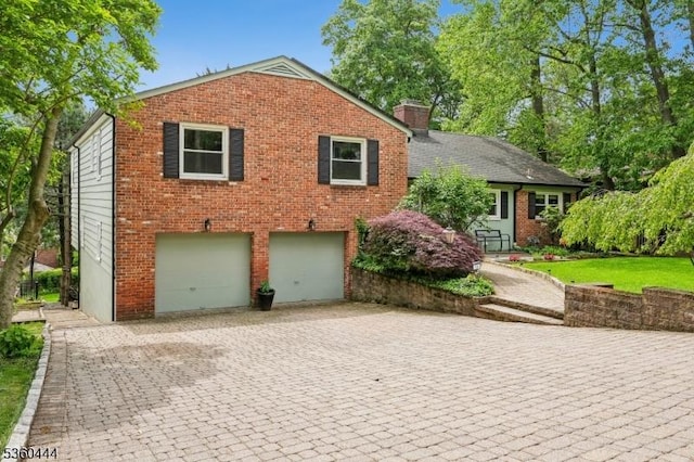 12 Beaumont Ter, West Orange Twp, NJ 07052 - view of front of house featuring an attached garage, brick siding, driveway, and a chimney