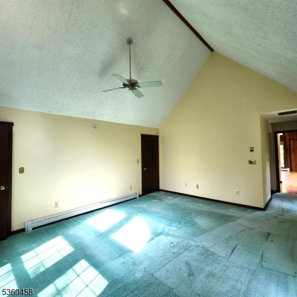 161 Neilson Rd, Wantage Twp, NJ 07461 - carpeted empty room with baseboard heating, ceiling fan, baseboards, a textured ceiling, and high vaulted ceiling