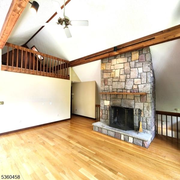 161 Neilson Rd, Wantage Twp, NJ 07461 - unfurnished living room with high vaulted ceiling, ceiling fan, wood finished floors, baseboards, and a fireplace