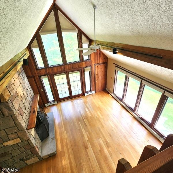 161 Neilson Rd, Wantage Twp, NJ 07461 - unfurnished living room with a textured ceiling, vaulted ceiling, ceiling fan, light wood finished floors, and french doors