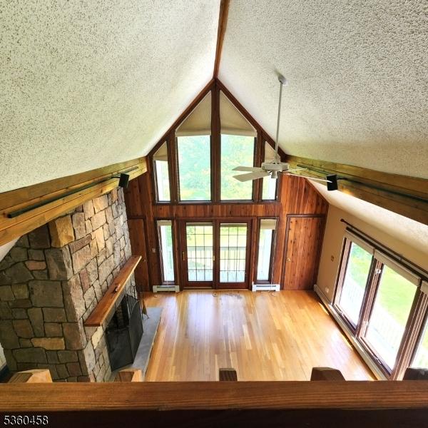 161 Neilson Rd, Wantage Twp, NJ 07461 - unfurnished living room featuring a textured ceiling, a ceiling fan, lofted ceiling, light wood-style floors, and a stone fireplace