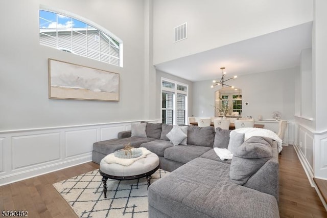 18 Hartley Ln, Bernards Twp, NJ 07920 - living room featuring a chandelier, wood finished floors, a decorative wall, wainscoting, and a high ceiling