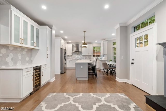 18 Hartley Ln, Bernards Twp, NJ 07920 - kitchen with wall chimney range hood, freestanding refrigerator, beverage cooler, a breakfast bar, and decorative backsplash
