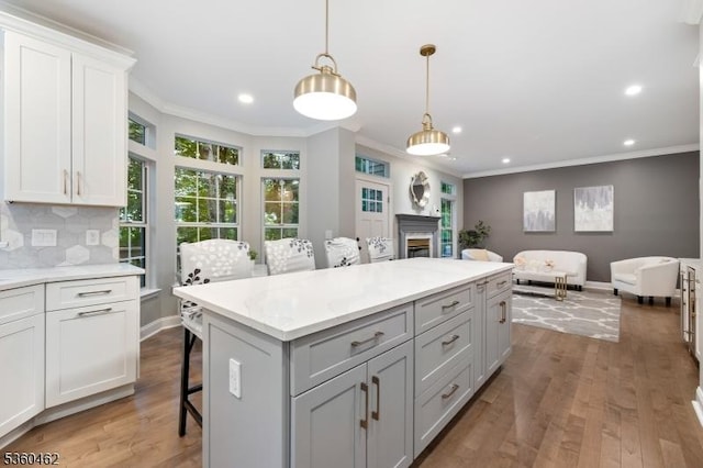 18 Hartley Ln, Bernards Twp, NJ 07920 - kitchen featuring wood finished floors, ornamental molding, a kitchen island, decorative backsplash, and recessed lighting