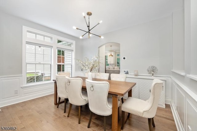 18 Hartley Ln, Bernards Twp, NJ 07920 - dining area featuring a chandelier, arched walkways, a decorative wall, light wood finished floors, and wainscoting