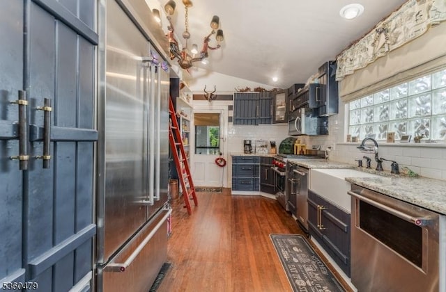 44 Main St, Califon Boro, NJ 07830 - kitchen featuring premium appliances, backsplash, vaulted ceiling, dark wood-style floors, and light stone counters