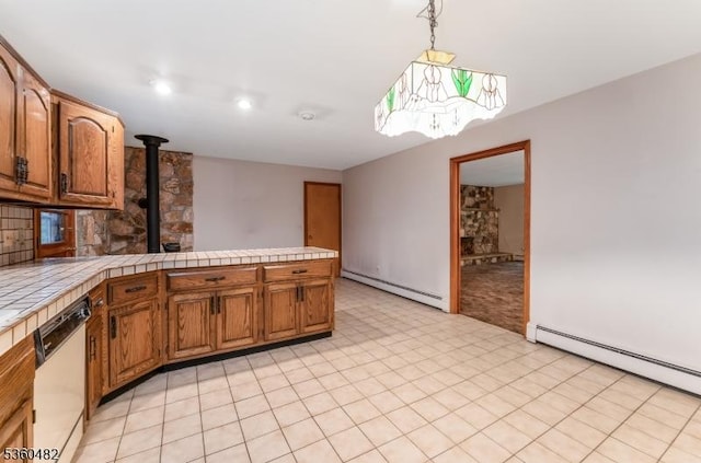 125 Free Union Rd, Liberty Twp, NJ 07823 - kitchen featuring a baseboard heating unit, dishwasher, tile counters, a wood stove, and brown cabinetry
