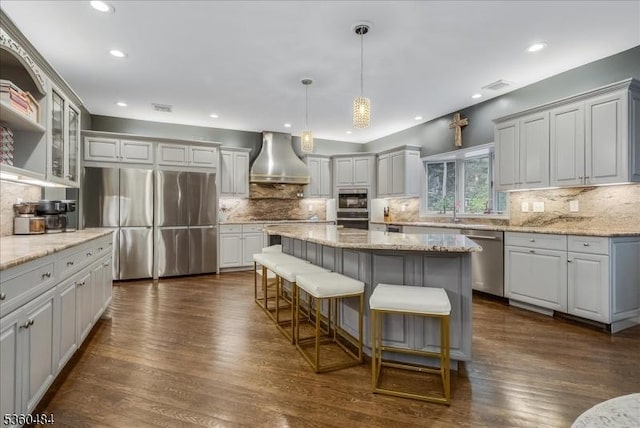 95 Underrock Rd, Sparta Twp, NJ 07871 - kitchen featuring stainless steel appliances, wall chimney range hood, tasteful backsplash, a breakfast bar area, and a center island