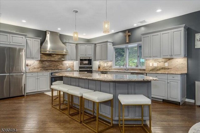 95 Underrock Rd, Sparta Twp, NJ 07871 - kitchen with stainless steel appliances, wall chimney range hood, backsplash, a center island, and recessed lighting
