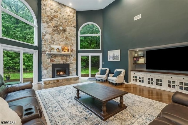 95 Underrock Rd, Sparta Twp, NJ 07871 - living room featuring wood finished floors, a high ceiling, a stone fireplace, and baseboards