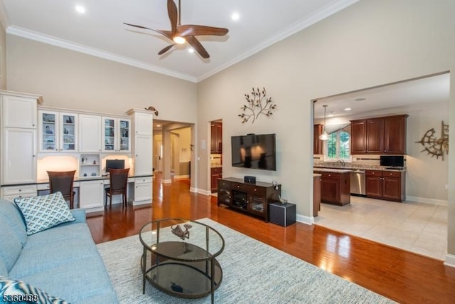 53 Patriots Way, Franklin Twp, NJ 08873 - living area featuring a ceiling fan, ornamental molding, baseboards, light wood-style flooring, and a towering ceiling