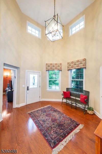 53 Patriots Way, Franklin Twp, NJ 08873 - entryway with a towering ceiling, wood finished floors, healthy amount of natural light, and a chandelier