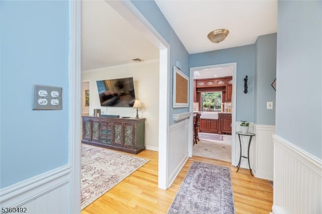 107 Shady Ln, Randolph Twp, NJ 07869 - corridor featuring light wood finished floors, a wainscoted wall, and a decorative wall