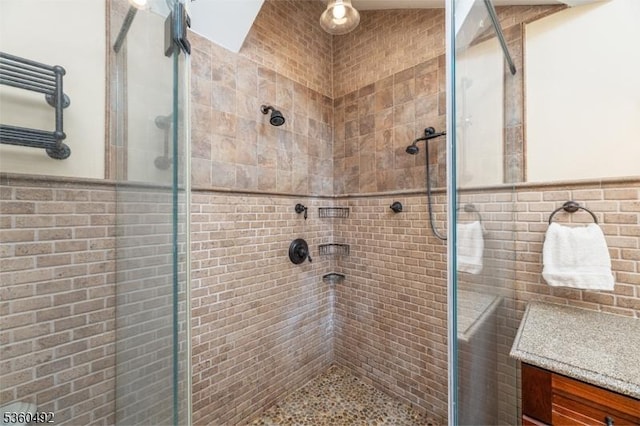107 Shady Ln, Randolph Twp, NJ 07869 - full bath featuring a stall shower, tile walls, wainscoting, and vanity
