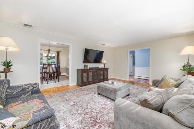 107 Shady Ln, Randolph Twp, NJ 07869 - living room with wood finished floors, a chandelier, baseboard heating, ornamental molding, and baseboards