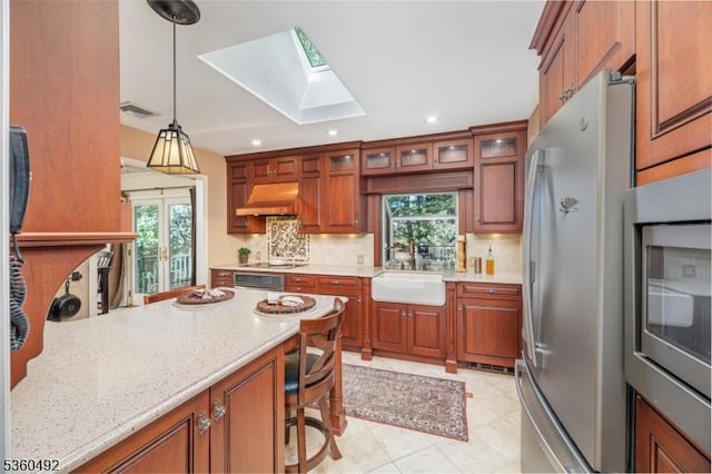 107 Shady Ln, Randolph Twp, NJ 07869 - kitchen with stainless steel appliances, a skylight, a sink, under cabinet range hood, and backsplash