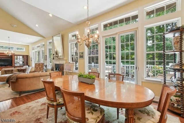 81 Schindler Way, Fairfield Twp, NJ 07004 - dining room featuring a chandelier, wood finished floors, healthy amount of natural light, a fireplace, and high vaulted ceiling