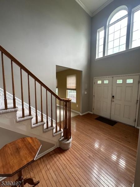 30 Julie Ct, Franklin Twp, NJ 08873 - entryway featuring hardwood / wood-style flooring, a high ceiling, stairway, crown molding, and healthy amount of natural light
