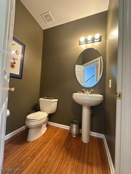 30 Julie Ct, Franklin Twp, NJ 08873 - half bathroom featuring toilet, wood finished floors, baseboards, and a sink