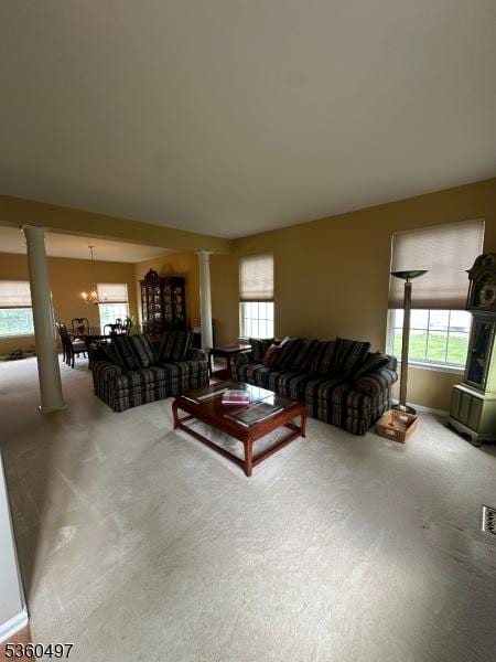 30 Julie Ct, Franklin Twp, NJ 08873 - carpeted living area featuring decorative columns, a chandelier, and baseboards