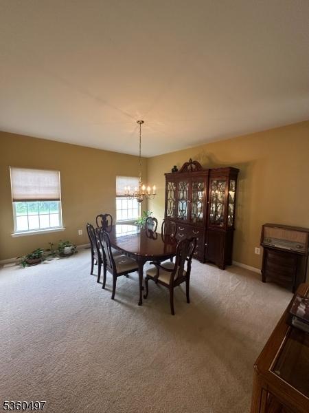 30 Julie Ct, Franklin Twp, NJ 08873 - dining room with light carpet, a chandelier, and baseboards