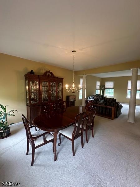 30 Julie Ct, Franklin Twp, NJ 08873 - dining room with carpet flooring, decorative columns, and a chandelier