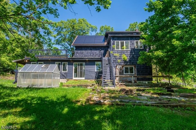 98 Asbury Rd, Independence Twp, NJ 07840 - back of property with a greenhouse, solar panels, stairs, an outdoor structure, and a lawn