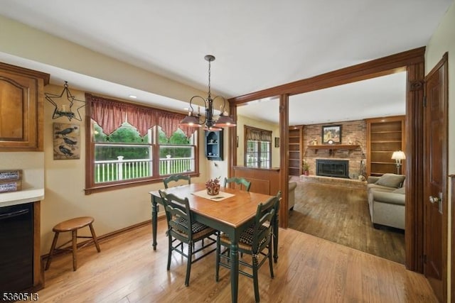 15 Fox Run, Parsippany-Troy Hills Twp, NJ 07834 - dining room featuring light wood-style flooring, a brick fireplace, a chandelier, baseboards, and built in shelves