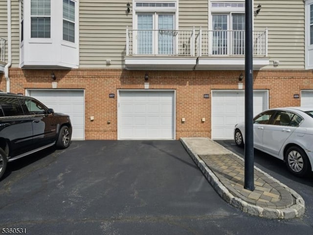 1007 Cunningham Ct Unit 1007, Belleville Twp, NJ 07109 - view of home's exterior featuring an attached garage, driveway, brick siding, and a balcony
