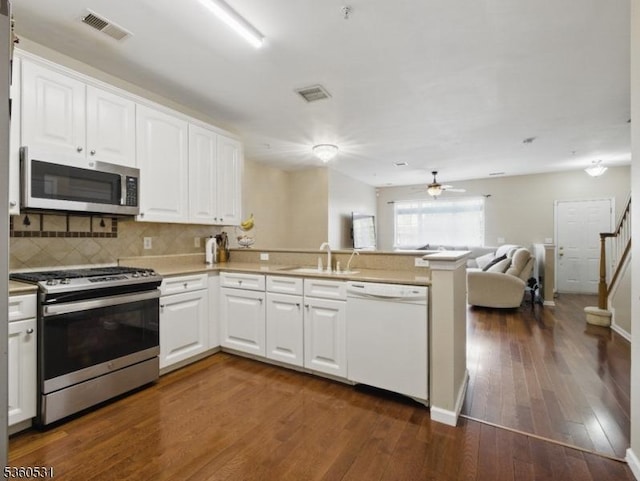 1007 Cunningham Ct Unit 1007, Belleville Twp, NJ 07109 - kitchen with stainless steel appliances, a sink, a peninsula, backsplash, and white cabinets