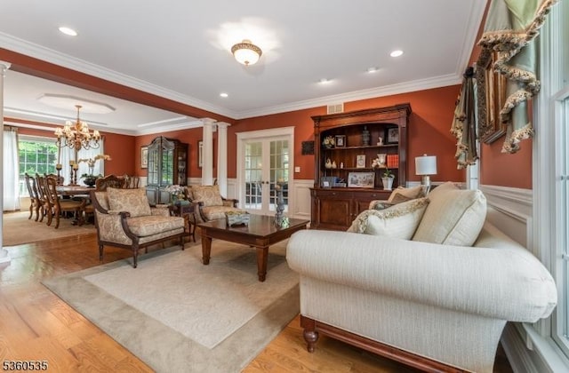 19 Britton Rd, Delaware Twp, NJ 08559 - living room featuring ornate columns, crown molding, a chandelier, wainscoting, and wood finished floors