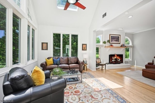 1 Colby Farm Rd, Chester Twp, NJ 07930 - living area with a skylight, high vaulted ceiling, wood finished floors, a ceiling fan, and a lit fireplace