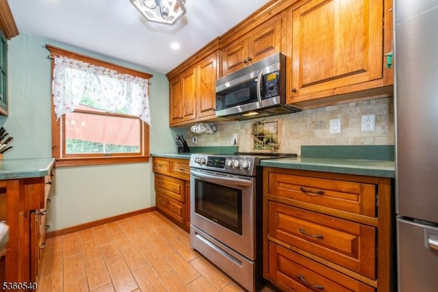 14 Lindberg Trl, Rockaway Twp, NJ 07866 - kitchen featuring stainless steel appliances, brown cabinetry, light wood-type flooring, decorative backsplash, and recessed lighting