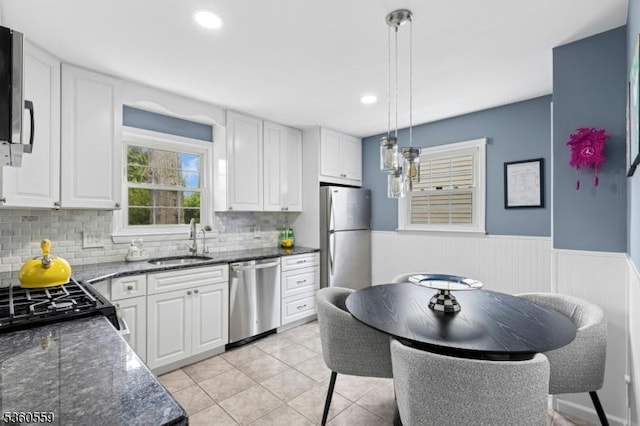392 Park View Dr, Scotch Plains Twp, NJ 07076 - kitchen featuring appliances with stainless steel finishes, a sink, white cabinetry, backsplash, and wainscoting