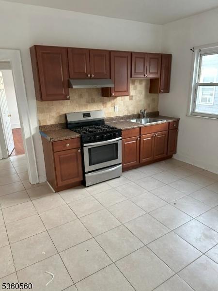 14 Nelson Pl, Maplewood Twp, NJ 07040 - kitchen with stainless steel gas range, under cabinet range hood, a sink, and tasteful backsplash