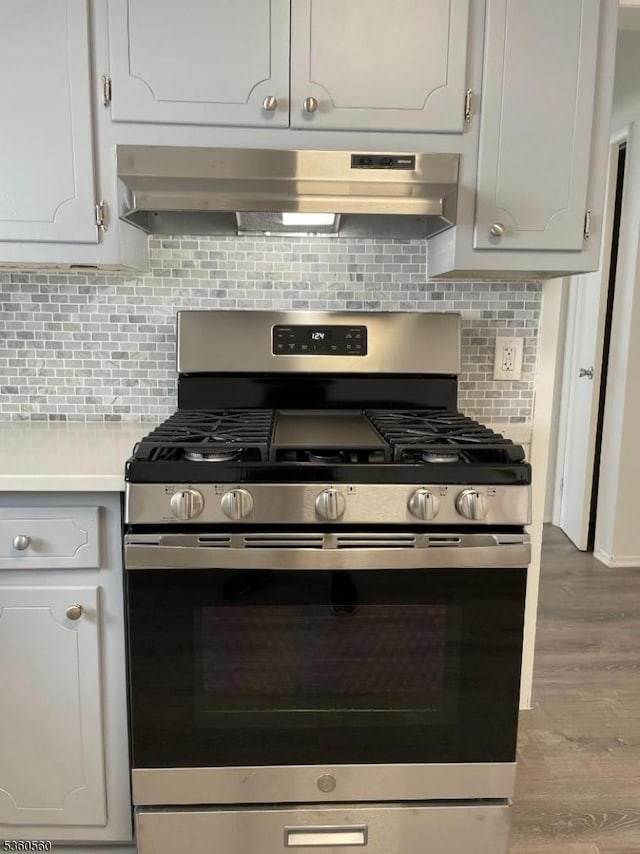 14 Nelson Pl, Maplewood Twp, NJ 07040 - kitchen with stainless steel gas range, under cabinet range hood, light countertops, wood finished floors, and tasteful backsplash