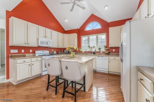 6 Apgar Ct, Raritan Twp, NJ 08822 - kitchen featuring white appliances, a breakfast bar area, light wood-style floors, light countertops, and high vaulted ceiling