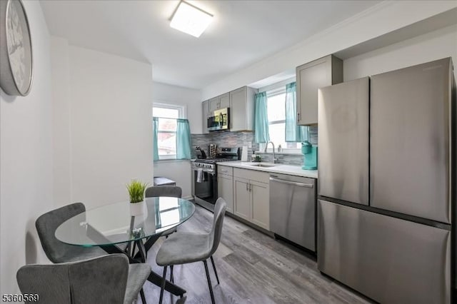 1036 Creger Ave, Union Twp, NJ 07083 - kitchen with stainless steel appliances, gray cabinets, light countertops, light wood finished floors, and decorative backsplash