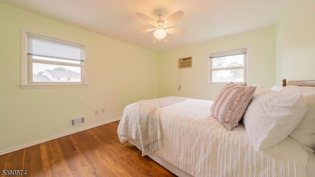 813 Riverbend Dr, Clark Twp, NJ 07066 - bedroom featuring a wall unit AC, wood finished floors, baseboards, and a ceiling fan