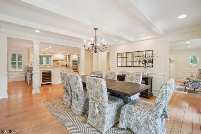 5 Barry Ln, Millburn Twp, NJ 07078 - dining area with beverage cooler, beam ceiling, light wood-type flooring, plenty of natural light, and a decorative wall