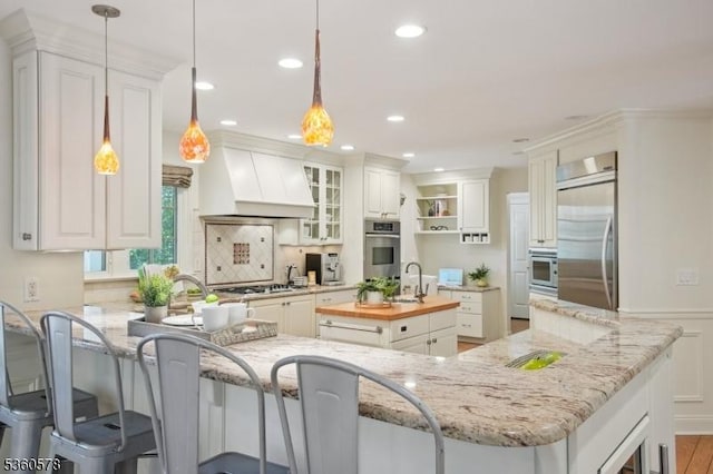 5 Barry Ln, Millburn Twp, NJ 07078 - kitchen featuring appliances with stainless steel finishes, premium range hood, a sink, a peninsula, and open shelves