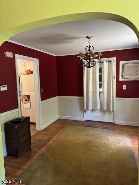 274 Diamond Hill Rd, Berkeley Heights Twp, NJ 07922 - unfurnished dining area with arched walkways, ornamental molding, wood finished floors, and a chandelier