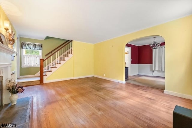 274 Diamond Hill Rd, Berkeley Heights Twp, NJ 07922 - unfurnished living room with arched walkways, a chandelier, wood finished floors, a fireplace, and stairway