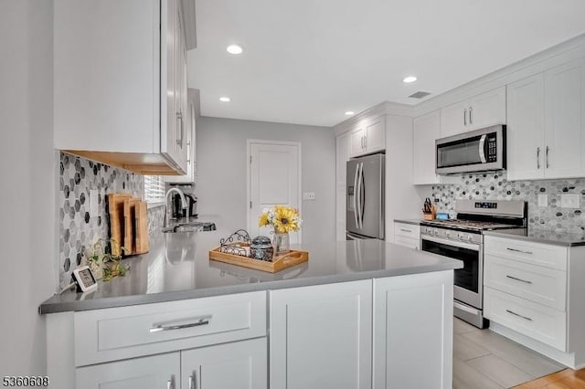 11 Anne St, Hillsborough Twp, NJ 08844 - kitchen with appliances with stainless steel finishes, white cabinets, decorative backsplash, a peninsula, and recessed lighting